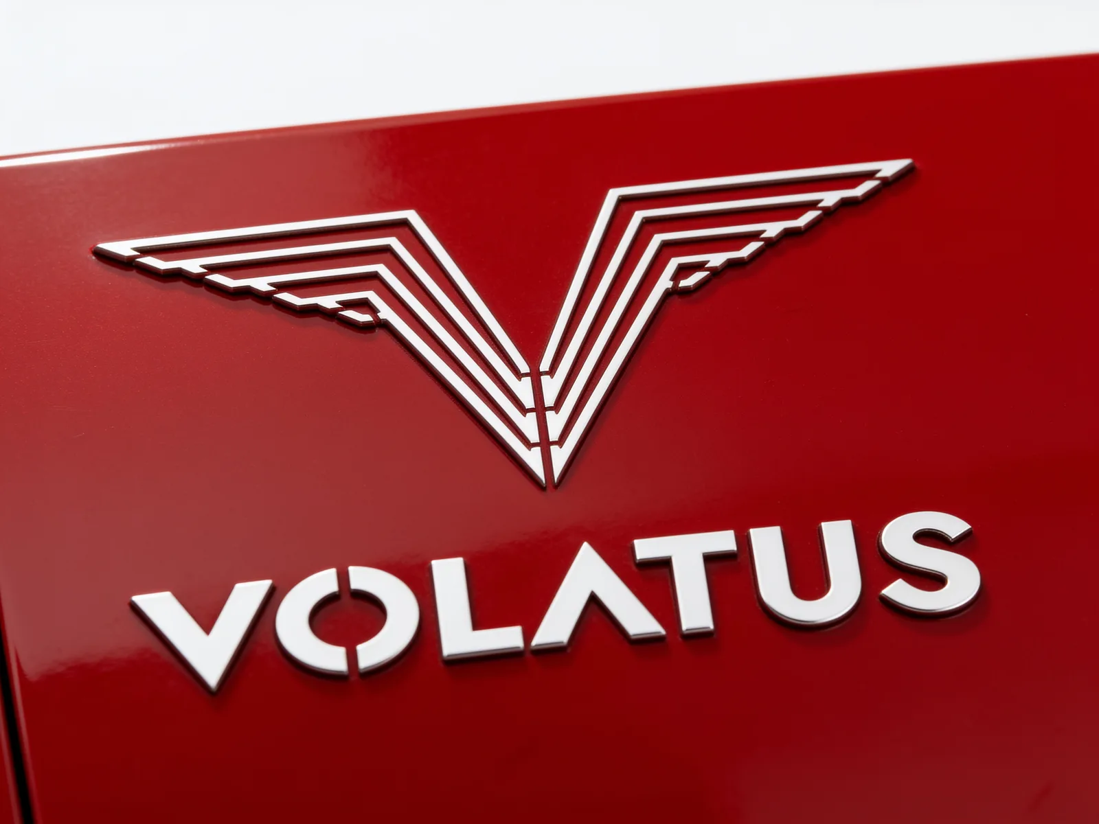 The cut-steel Volatus V-chevron and wordmark on a red charger enclosure on the Wisconsin fabrication floor